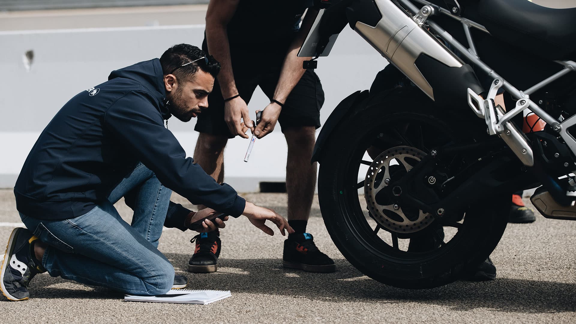 Triumph Tiger 1200 GT rear wheel and tyre being inspected